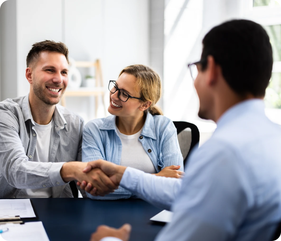 Couple shaking hands with businessman